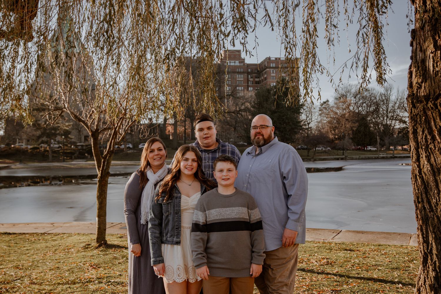 Family portrait series taken outdoors with trees and natural lighting.