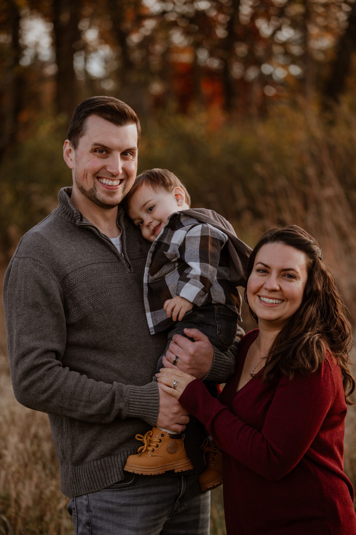 A couple shares intimate moments in a series of romantic autumn outdoor photos wearing burgundy and grey sweaters.
