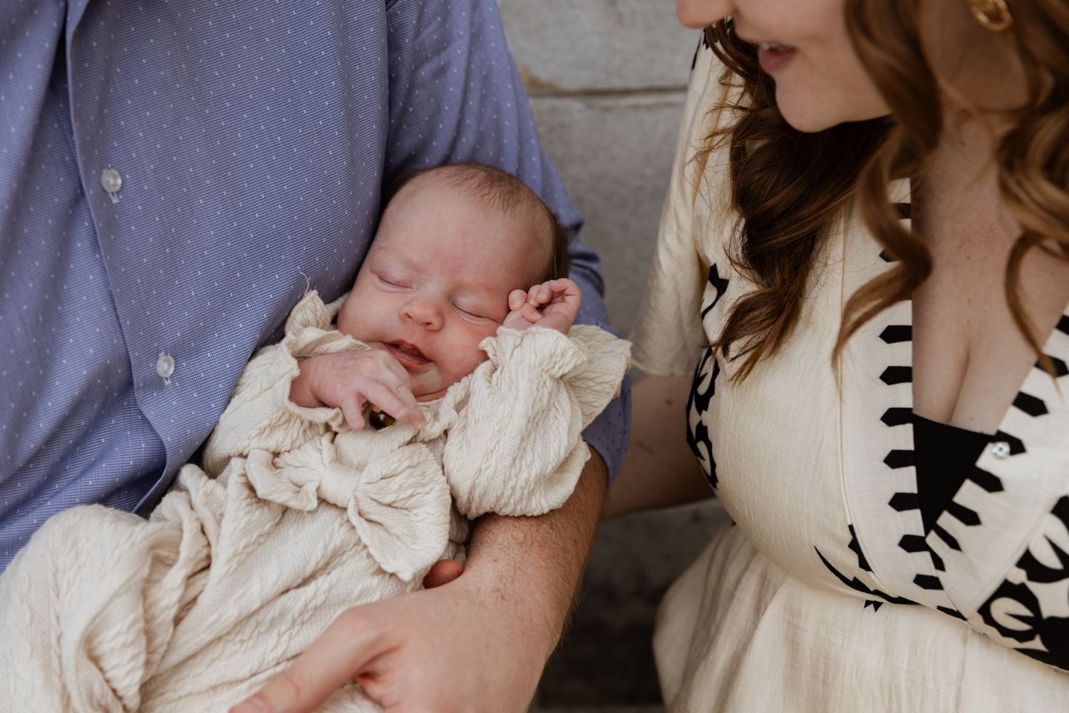 A tender moment between parents and their newborn baby in soft lighting.
