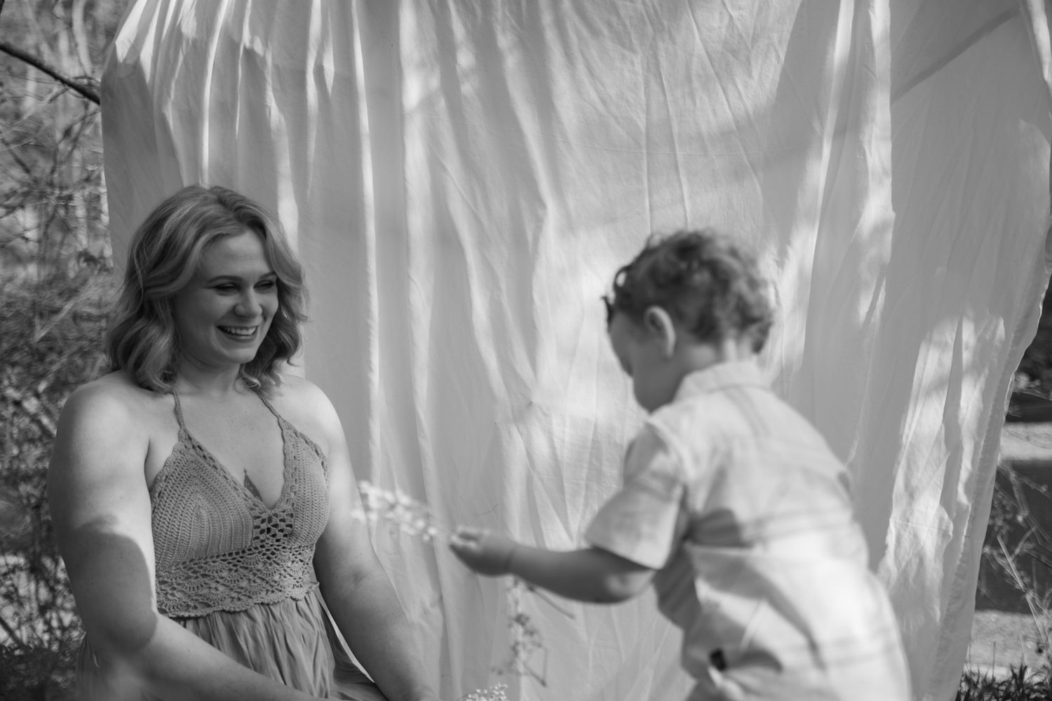 Sweet candid moments captured between parent and child against a white fabric backdrop.