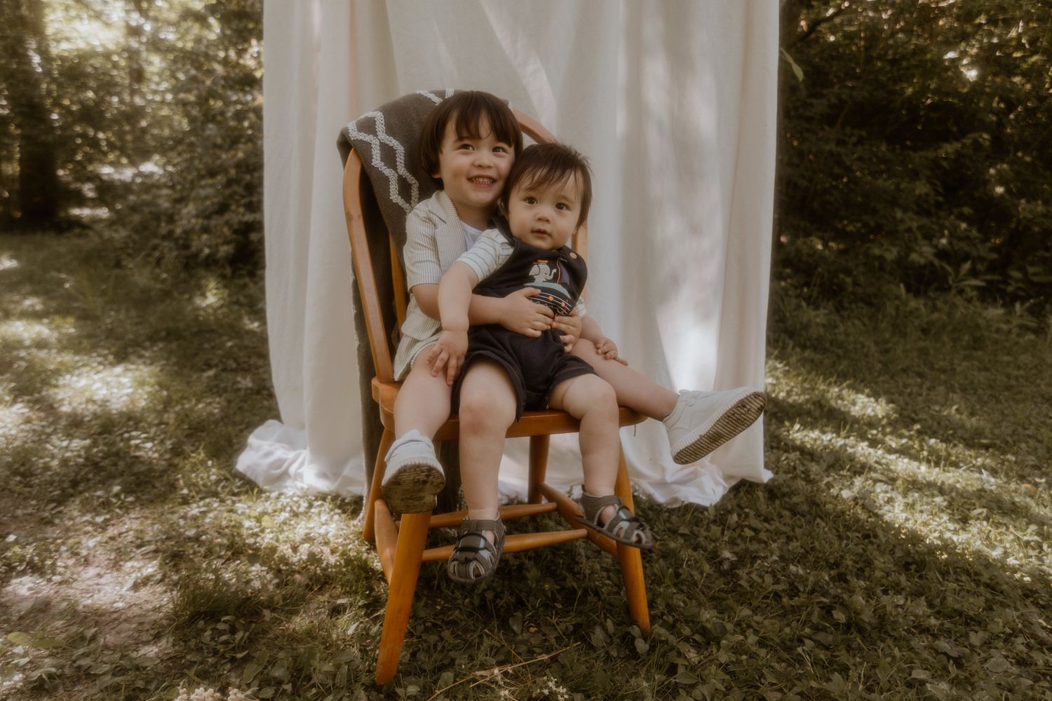 Candid family moments captured against a white backdrop in a sunlit outdoor setting.