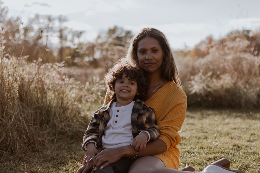 Mother and child share tender moments together in a sunlit outdoor setting.