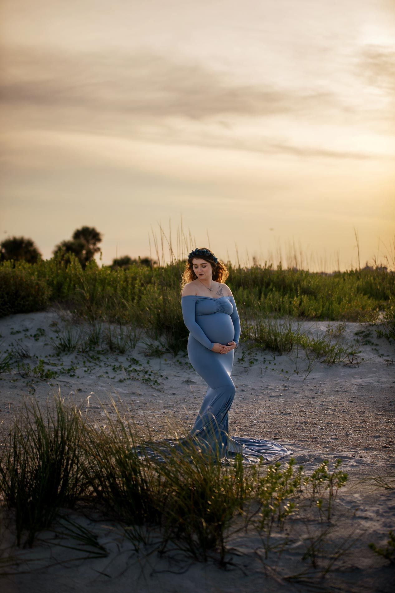 pregnant woman posing for maternity photography in beach boardwalk with husband and children