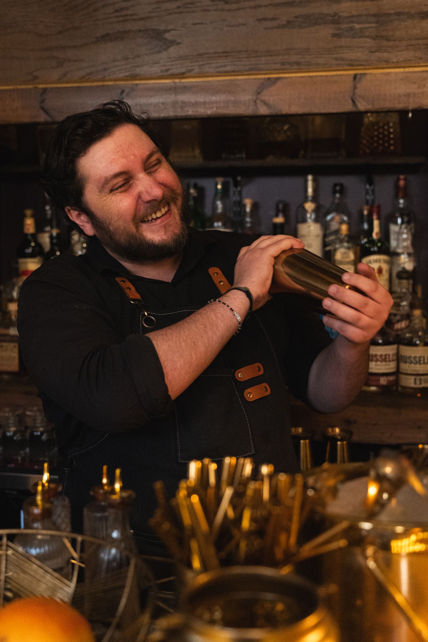 Cigar lounge ambiance with patrons enjoying premium cigars and drinks in a cozy, sophisticated environment.