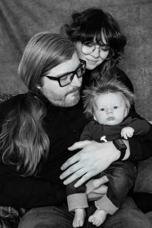 A black and white photo series showing intimate moments between a parent and baby in various tender poses.