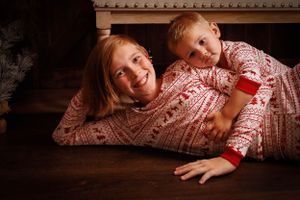 A series of connected photos showing a person in a red and white patterned jammies lying on a wooden floor.