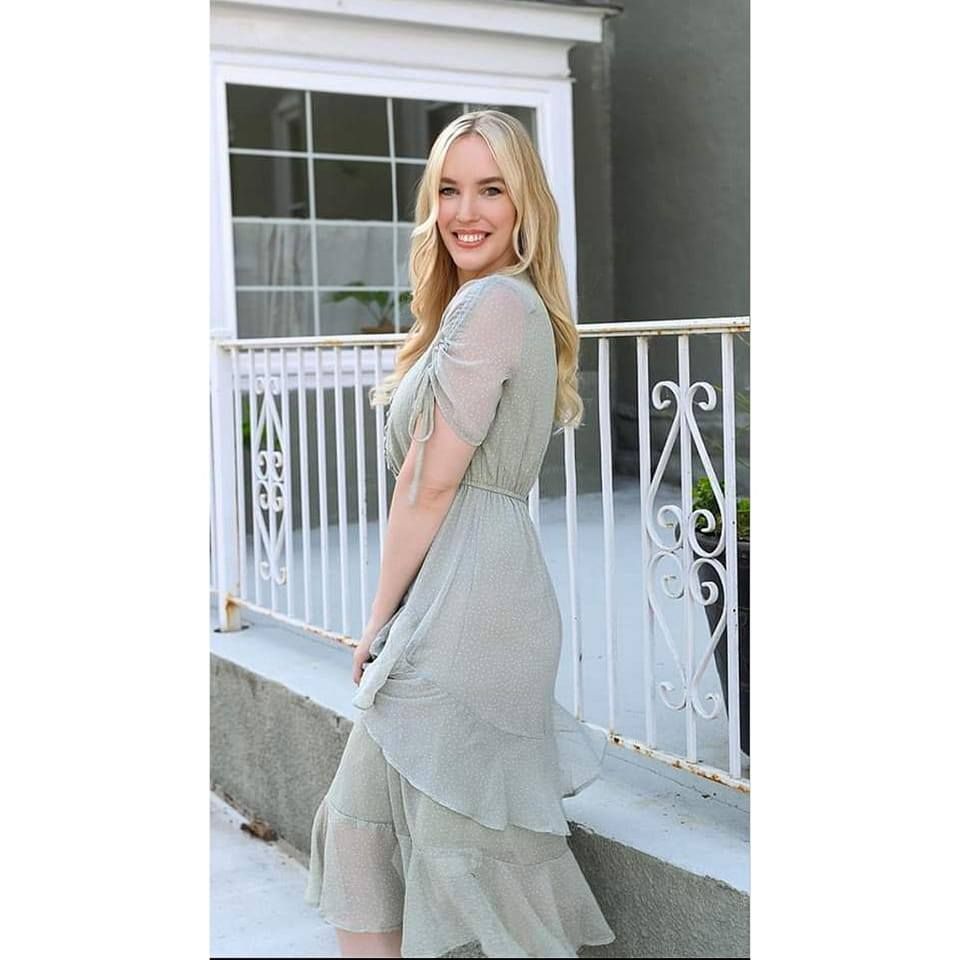 Woman in light gray loungewear set poses on white porch in natural morning light.