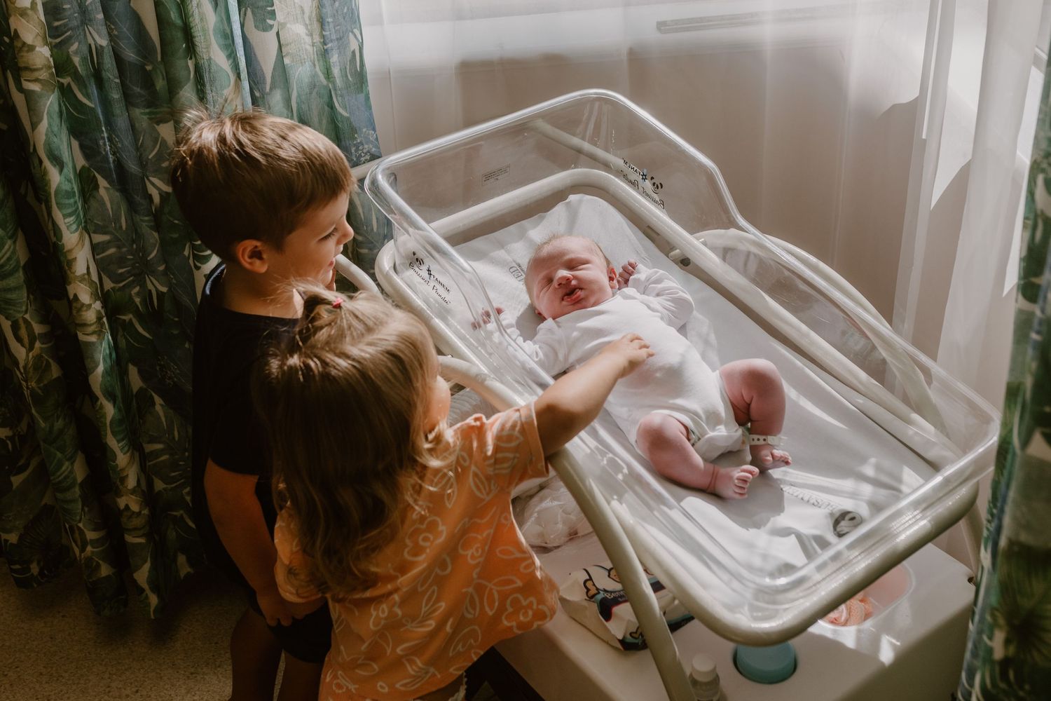 newborn baby in hospital with siblings