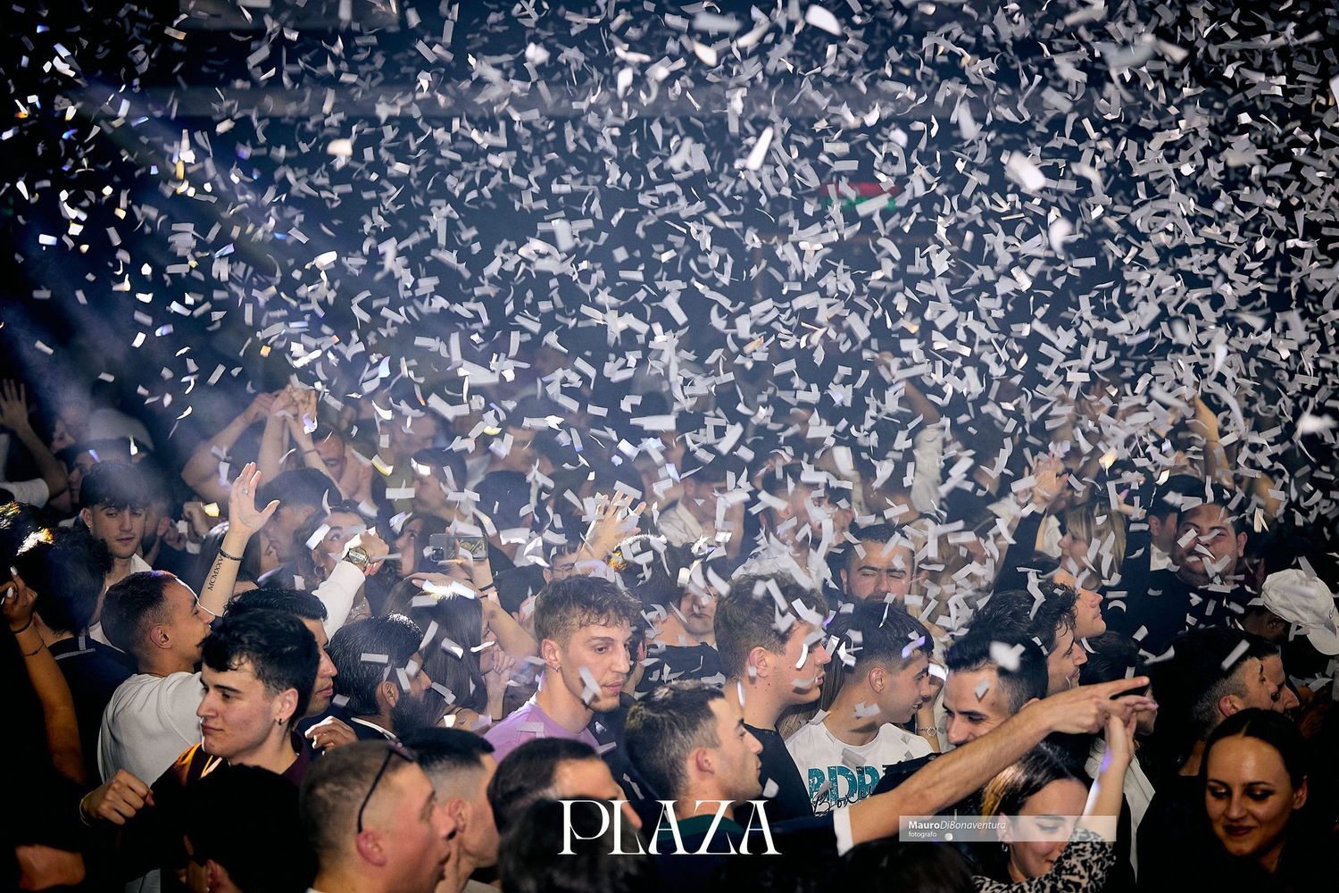 Confetti explodes over packed dance floor at Plaza nightclub during celebration.