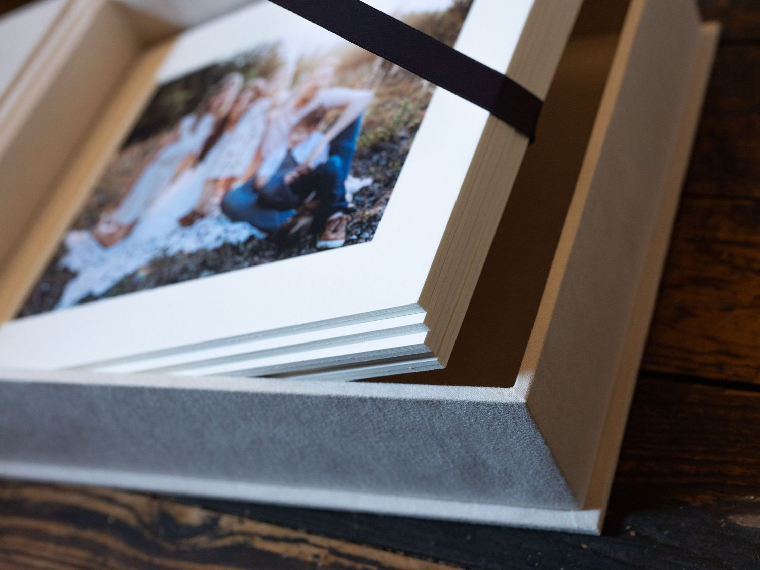 Close-up detail of white photo album pages with matted photographs.