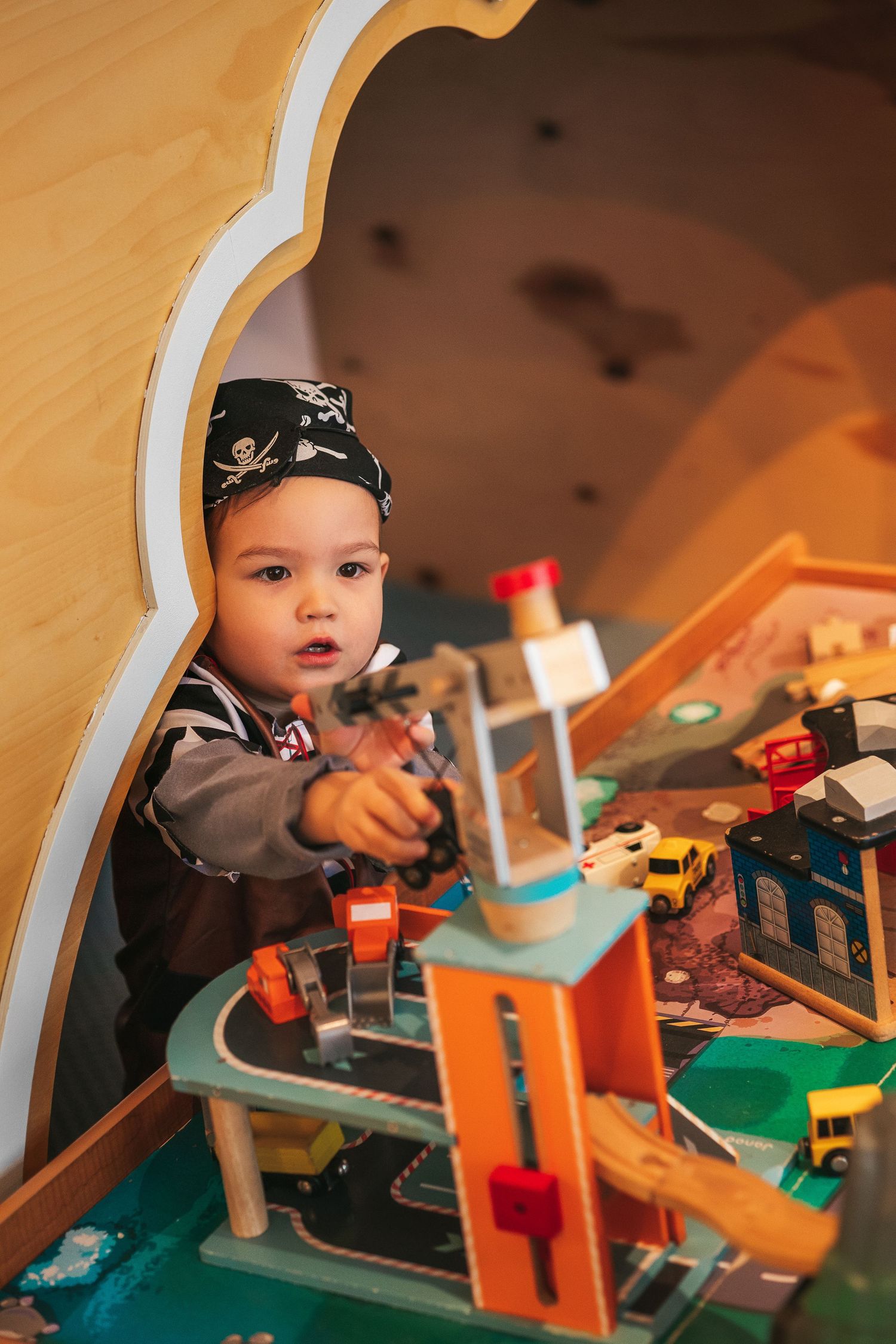 a boy dressed as a pirate plays in a light-filled room with toys in DEBESŲ MIESTAS.
