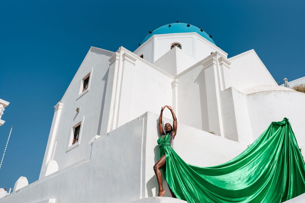White Greek church with emerald green flowing fabric draping down the building.