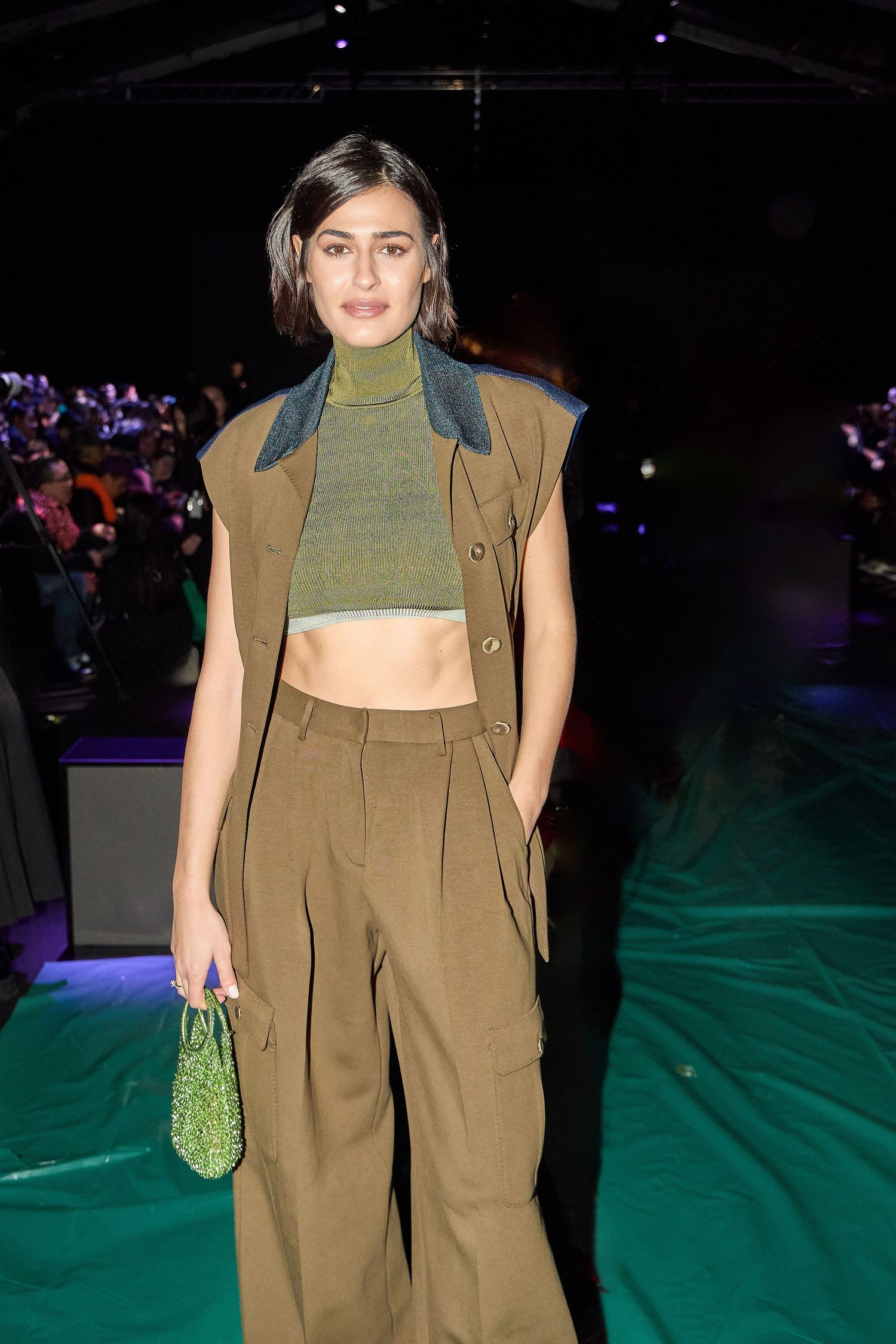 Fashionable outfit featuring olive green crop top and matching wide-leg pants with tan vest.