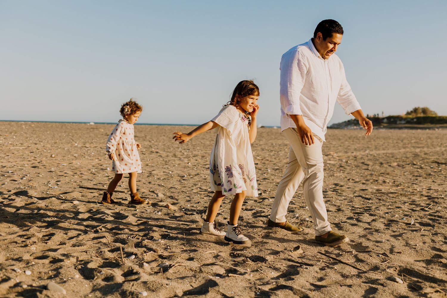 The girls Shasha and Romi are walking after their dad in a family photoshoot.