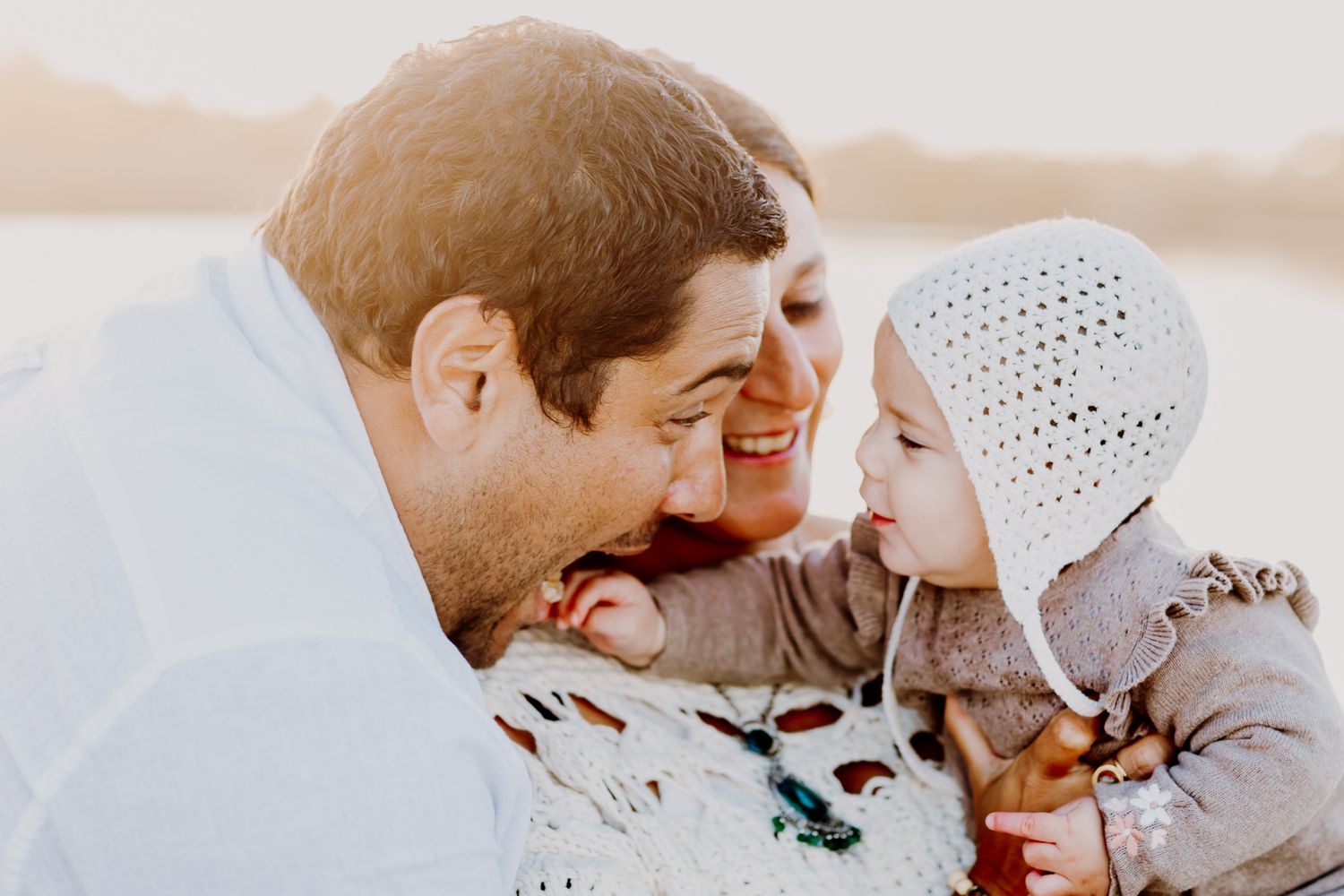 Father and mother looking at their baby and laughing.