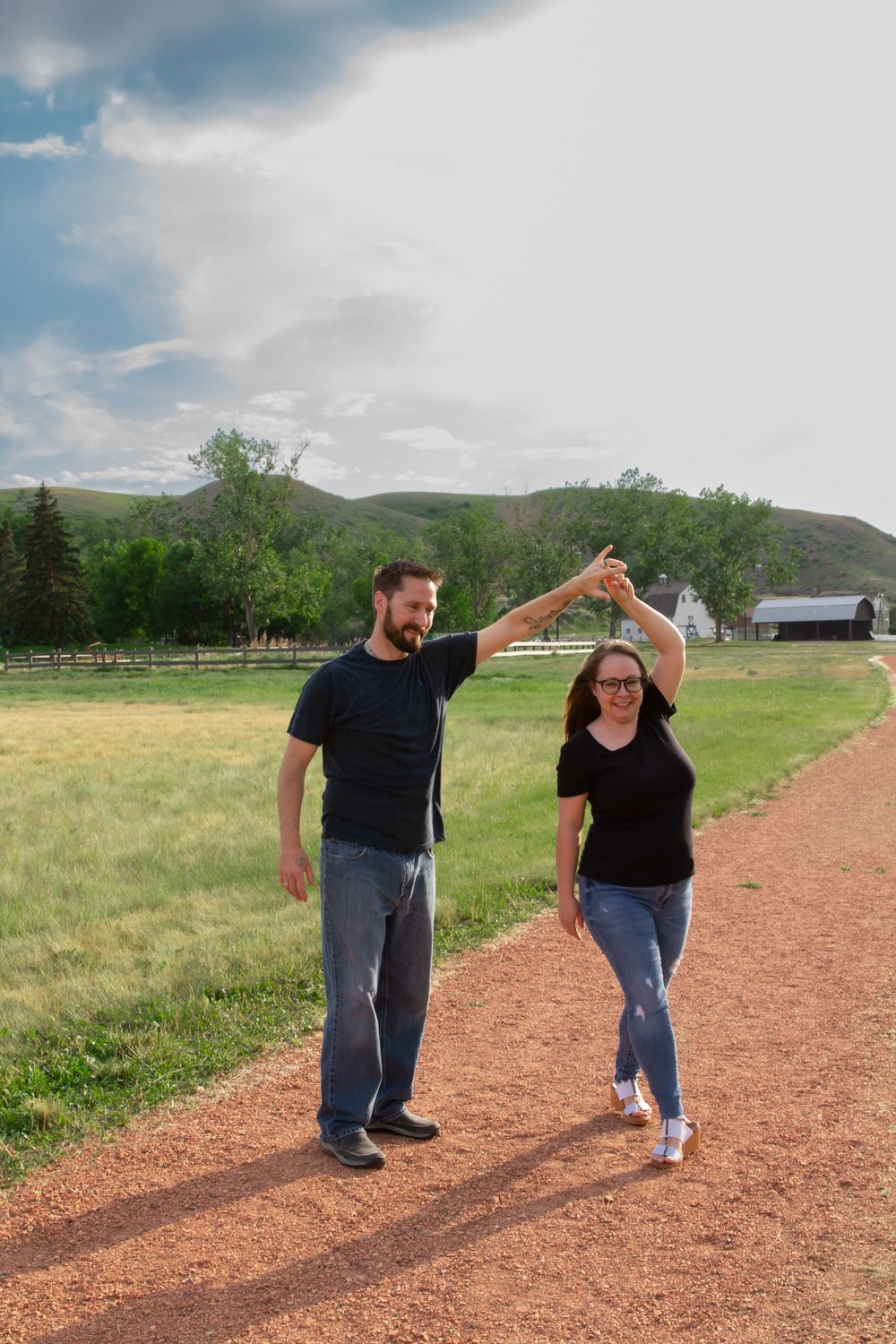 a couple dance on a red rock path.