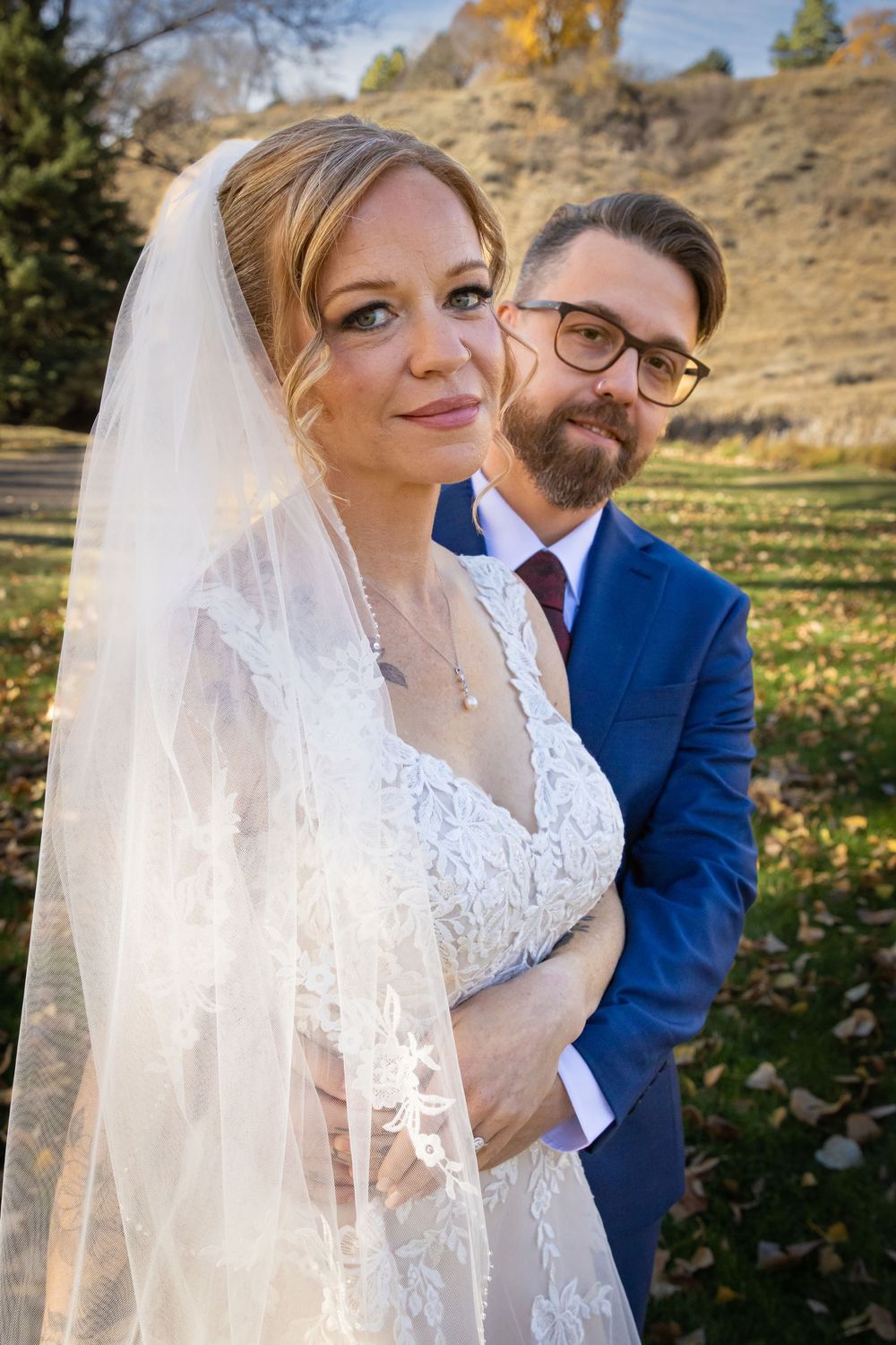 a bride & groom in a green field.