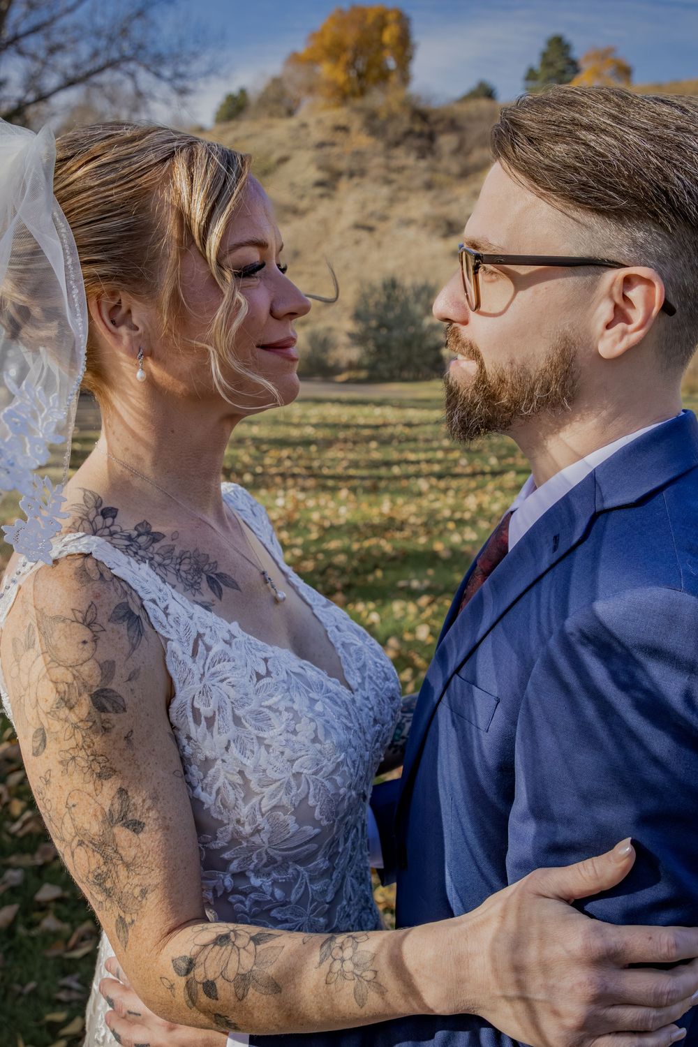 a bride & groom in a green field.
