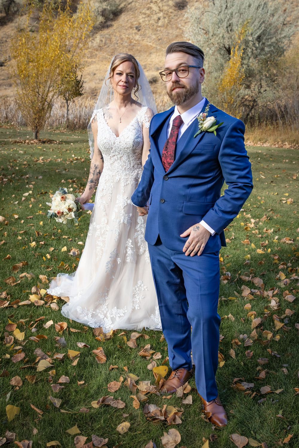 a bride & groom in a green field.