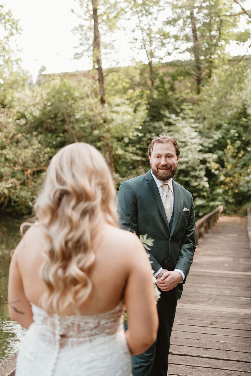 A first look moment captured on a wooden boardwalk in a forest setting.