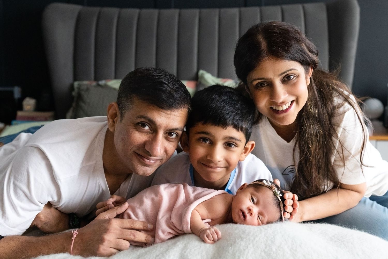 A family snuggles together on a gray couch in a series of candid moments showing warmth and connection.