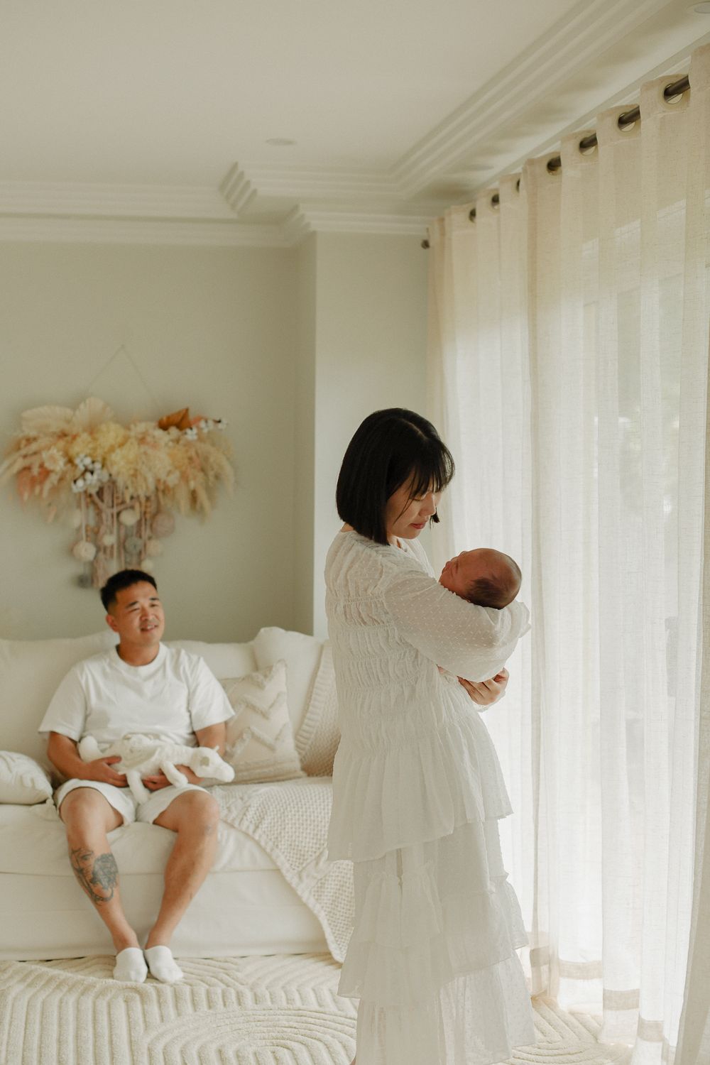 Family shares tender moment in bright studio in Bexley with pampas grass decor.