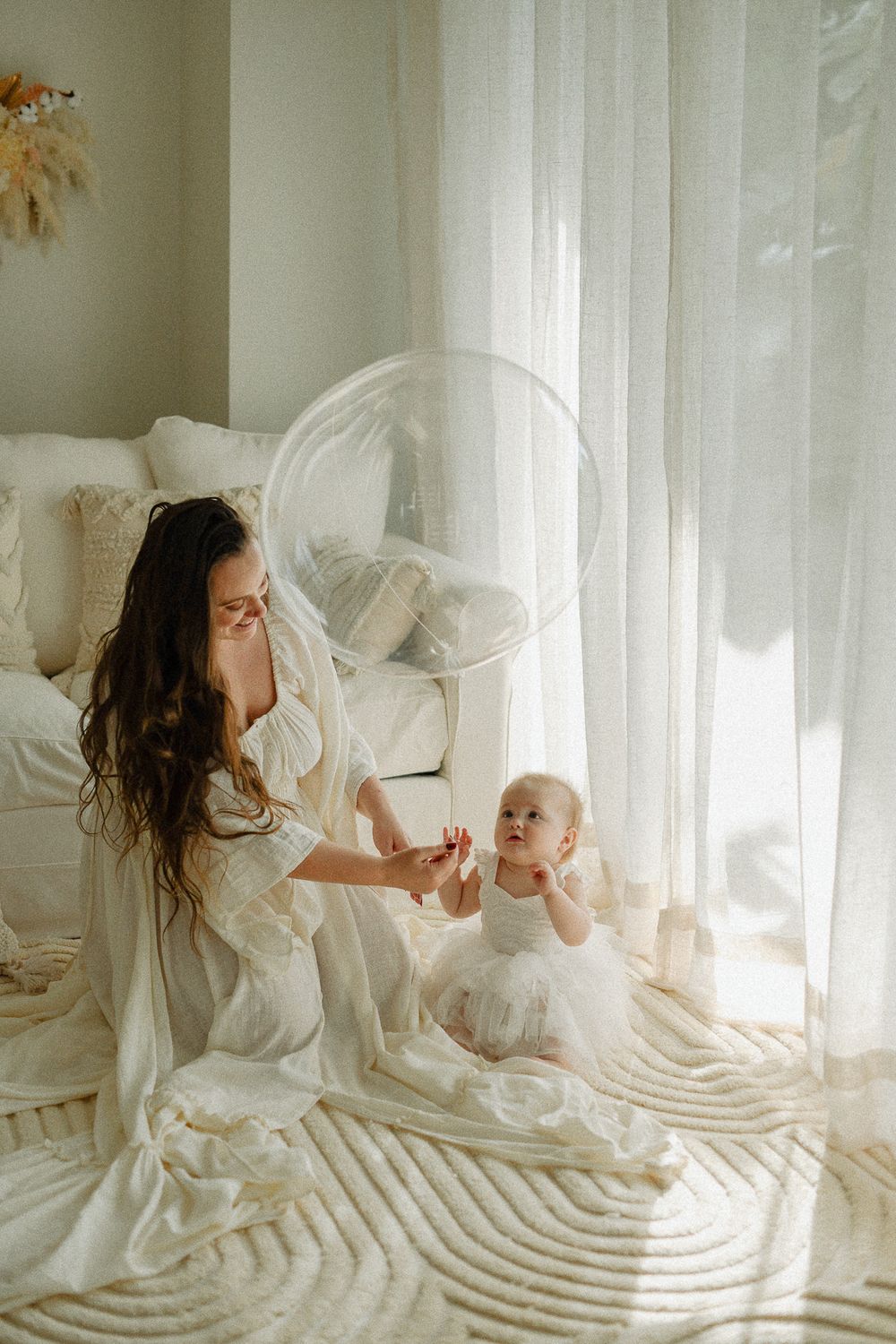 A sweet bonding moment captured in soft white tones and natural light.
