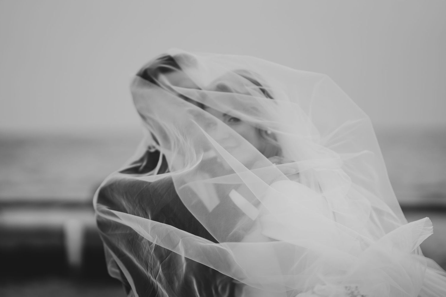 Flowing white wedding veil blowing gracefully in the wind.