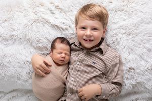 Sweet newborn photography session on white fluffy blanket showing peaceful sleeping poses.