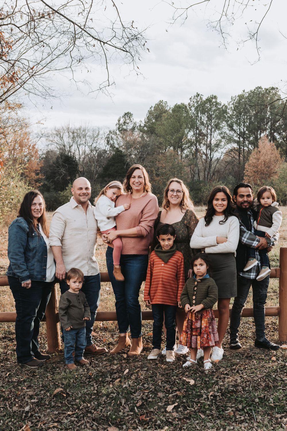 Extended family group portrait outdoors during fall season.