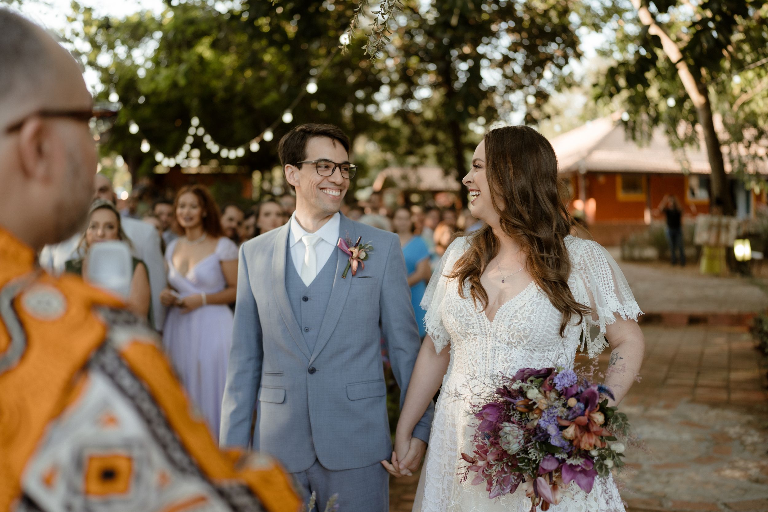 Wedding celebration with couple and guests in an outdoor garden setting.