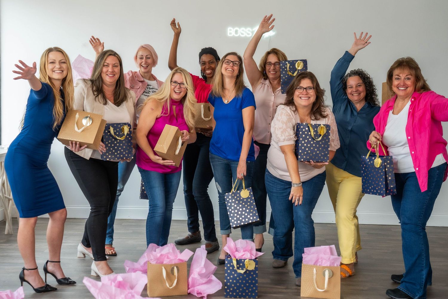 Group of people jumping and posing together in a bright indoor studio space.