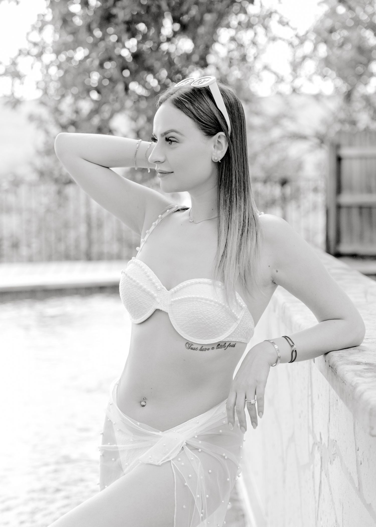 Black and white portrait in an elegant outdoor setting with natural lighting.