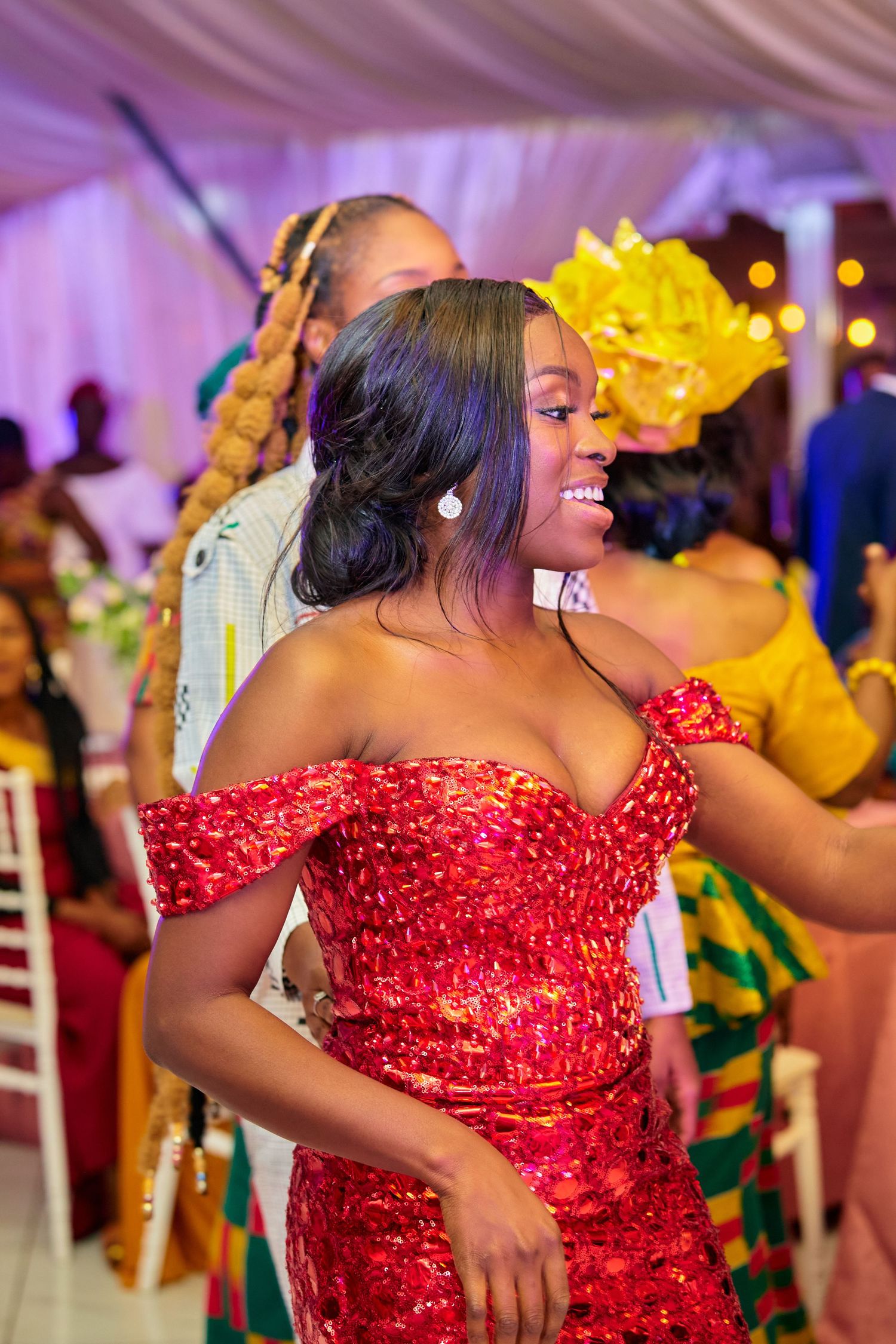 Dancer in sequined red gown performs enthusiastic moves at celebration.