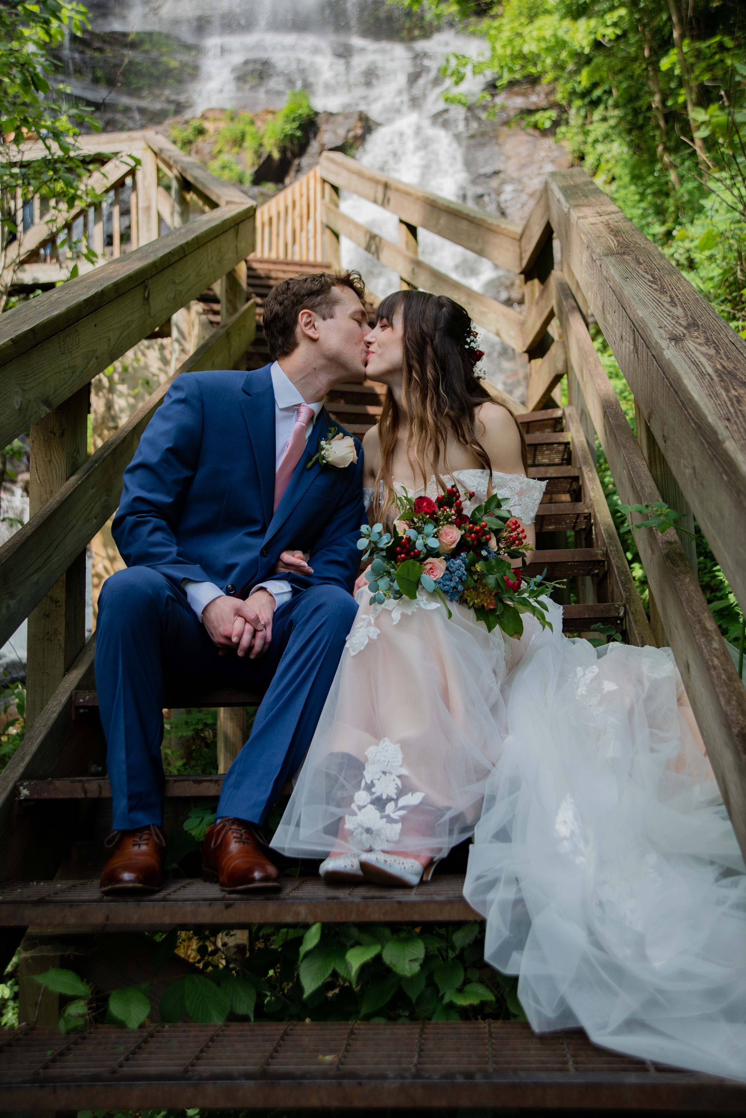 couple kiss in front of the waterfall at amicalola falls in north georgia wedding elopment