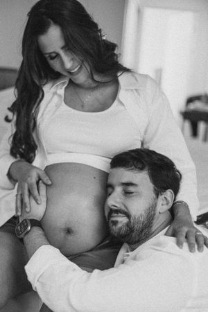 An intimate black and white maternity photo showing a tender moment.
