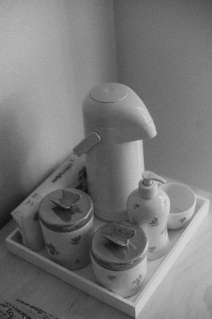 Collection of vintage teapots and cups arranged on white table.