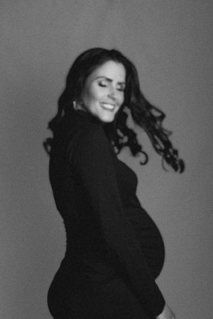 Dramatic black and white maternity photos with flowing hair movement.