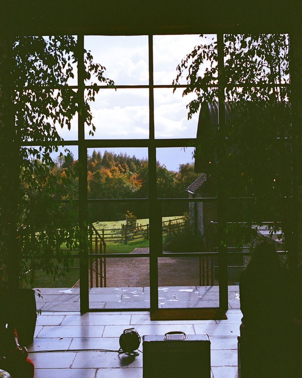 Large windows overlooking a scenic landscape with silhouettes in the foreground.