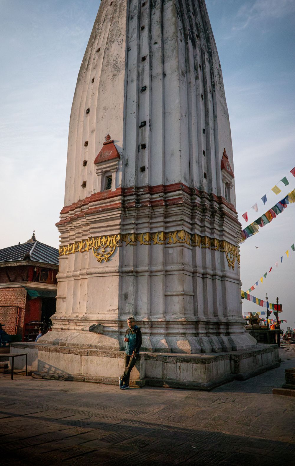 Traditional Nepali temple architecture featuring white stupa with decorative red and gold details.