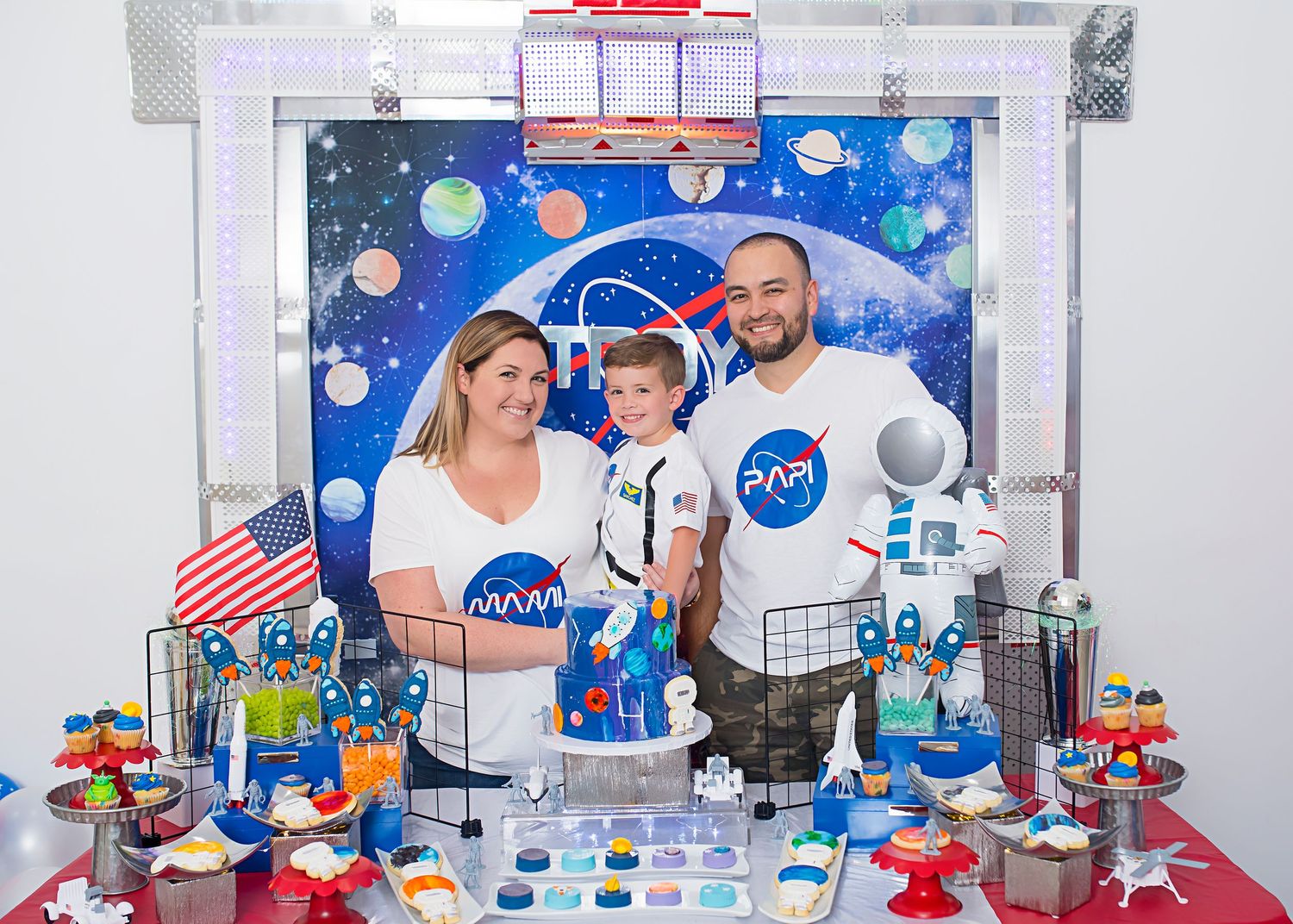 Space-themed party display with NASA decorations, planets, astronauts and colorful toy elements on a decorated table.