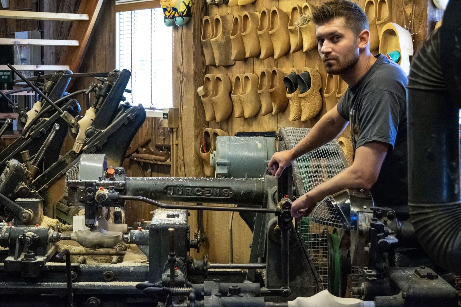 Craftsman working with traditional tools in a historic woodworking shop.