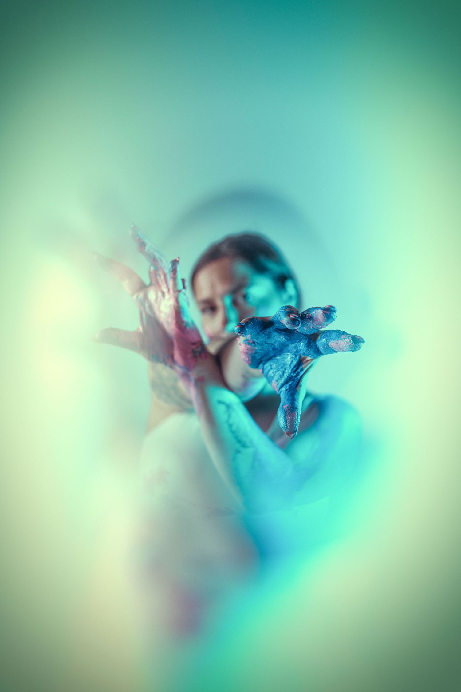 Ethereal underwater-style portrait with turquoise lighting and soft focus effects.
