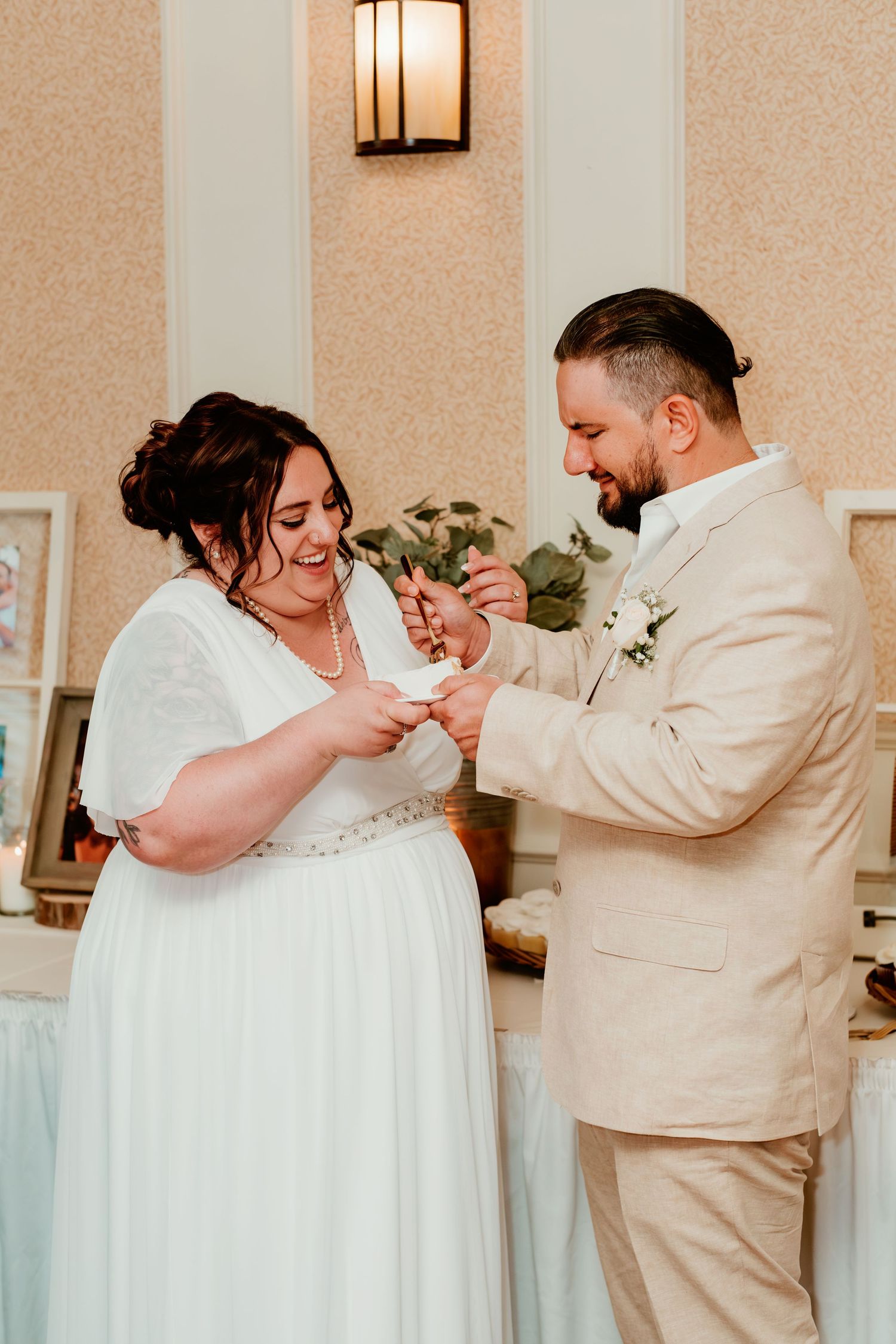 Wedding couple sharing a joyful moment during cake cutting ceremony.