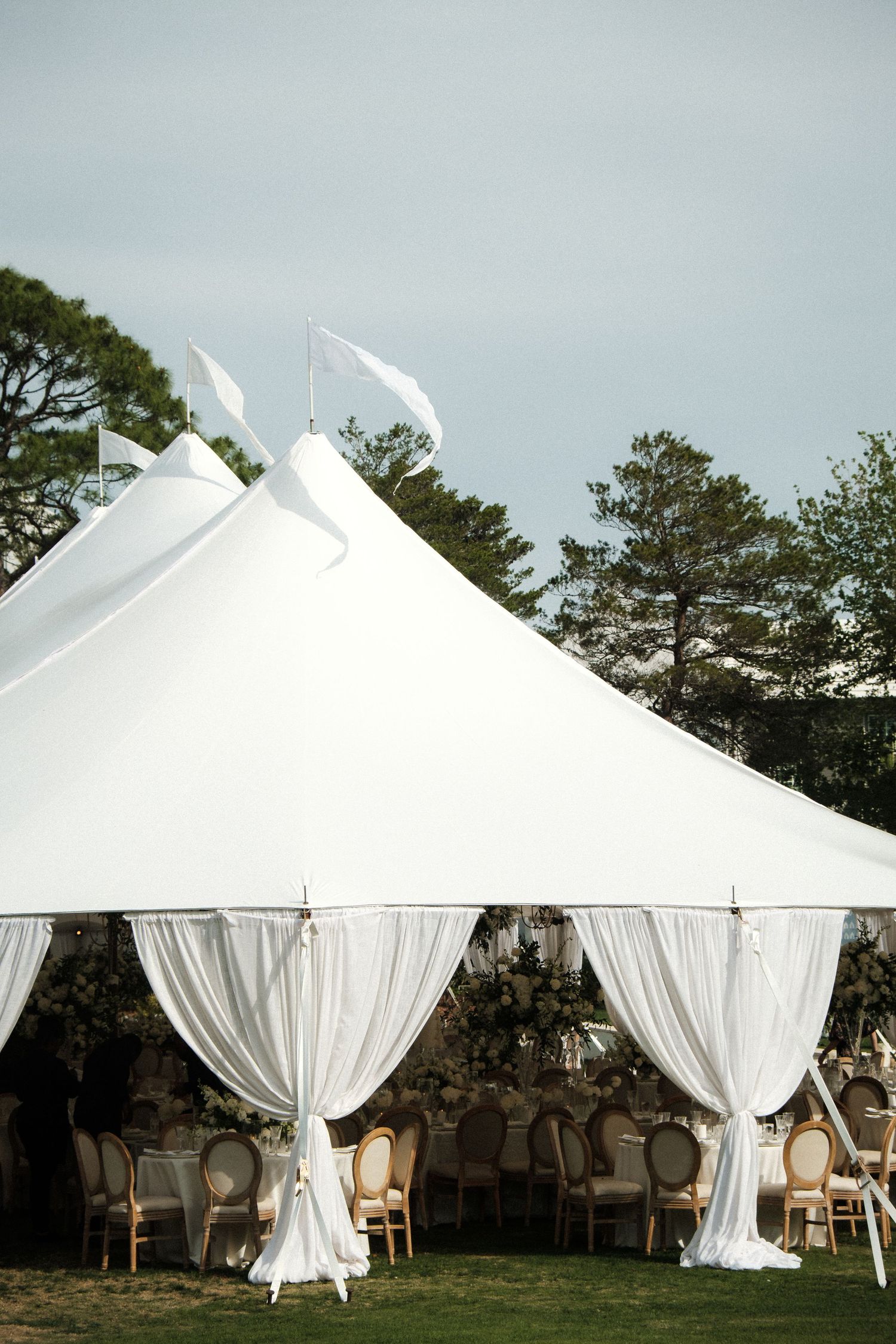 White tent peaks against moody grey sky creating minimalist geometric shapes.