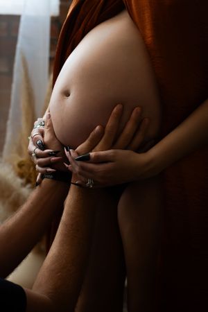 Dallas-Fort Worth maternity boudoir photo where a husband holds his wife's tummy.