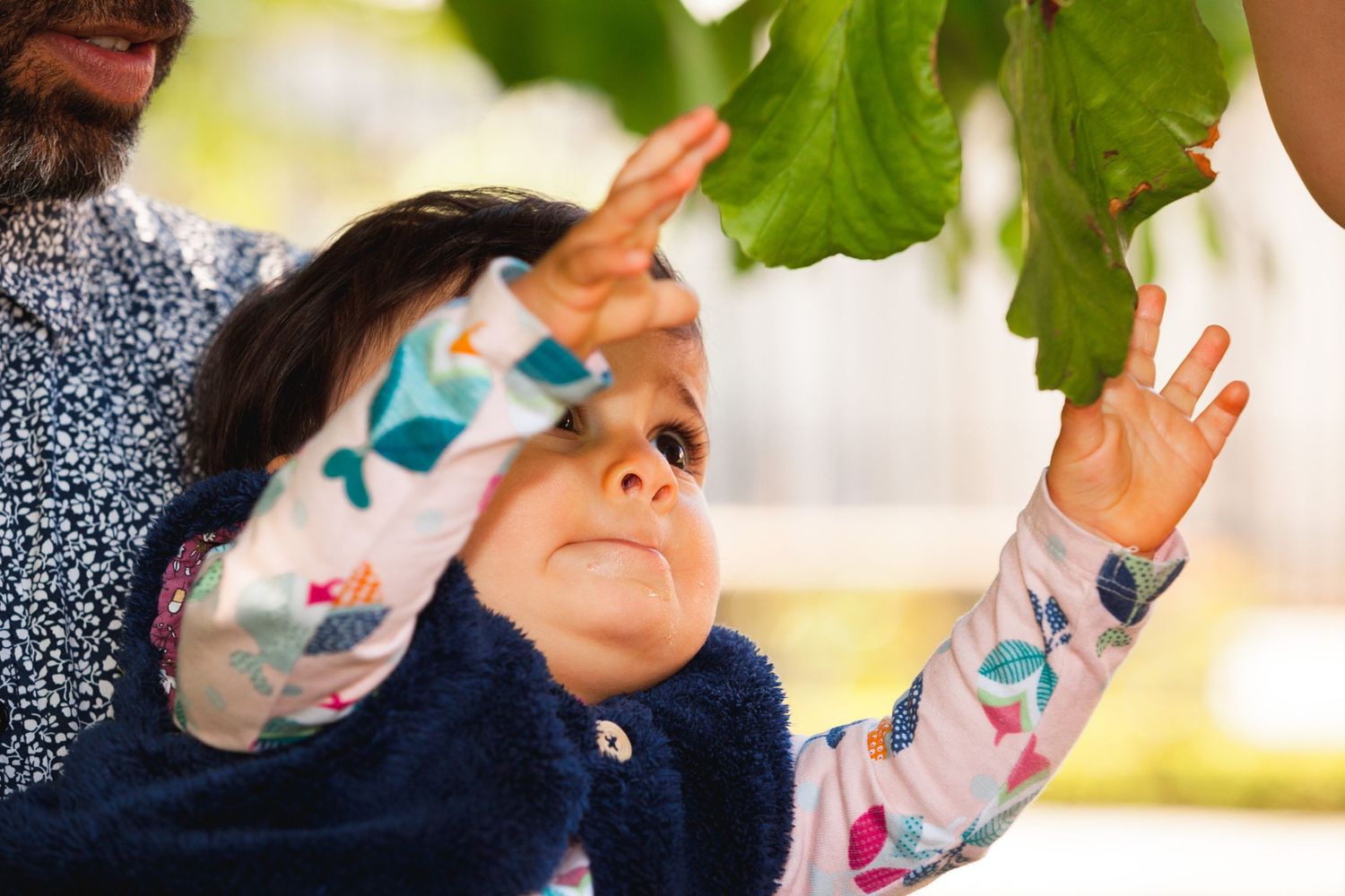 Enfant qui essaie d'attraper des feuilles dans un parc de Grenoble