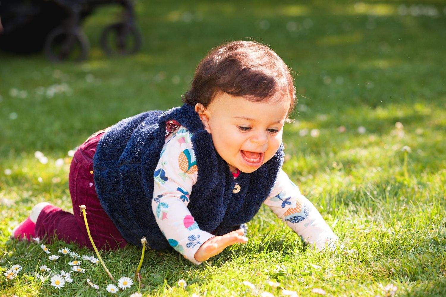 Bébé qui sourit en rampant dans l'herbe