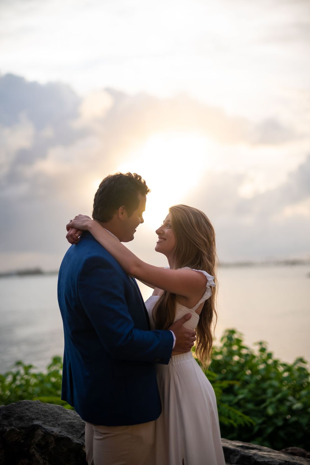 Romantic sunset portrait at a coastal location with soft lighting and ocean backdrop.