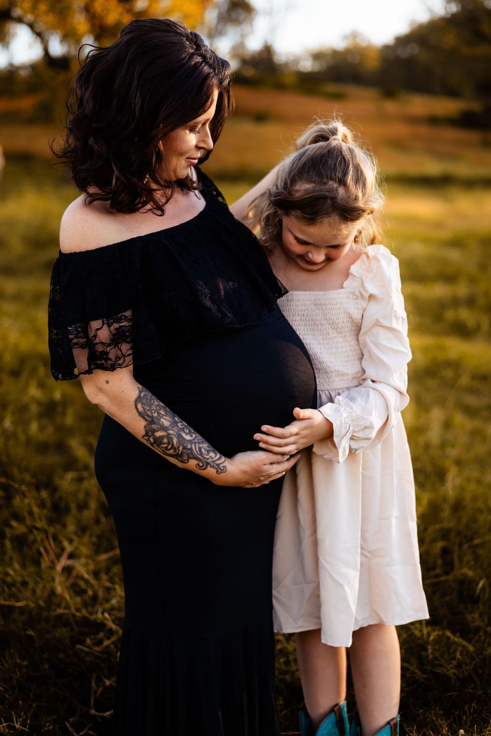 A touching maternity moment between mother and daughter in autumn light.